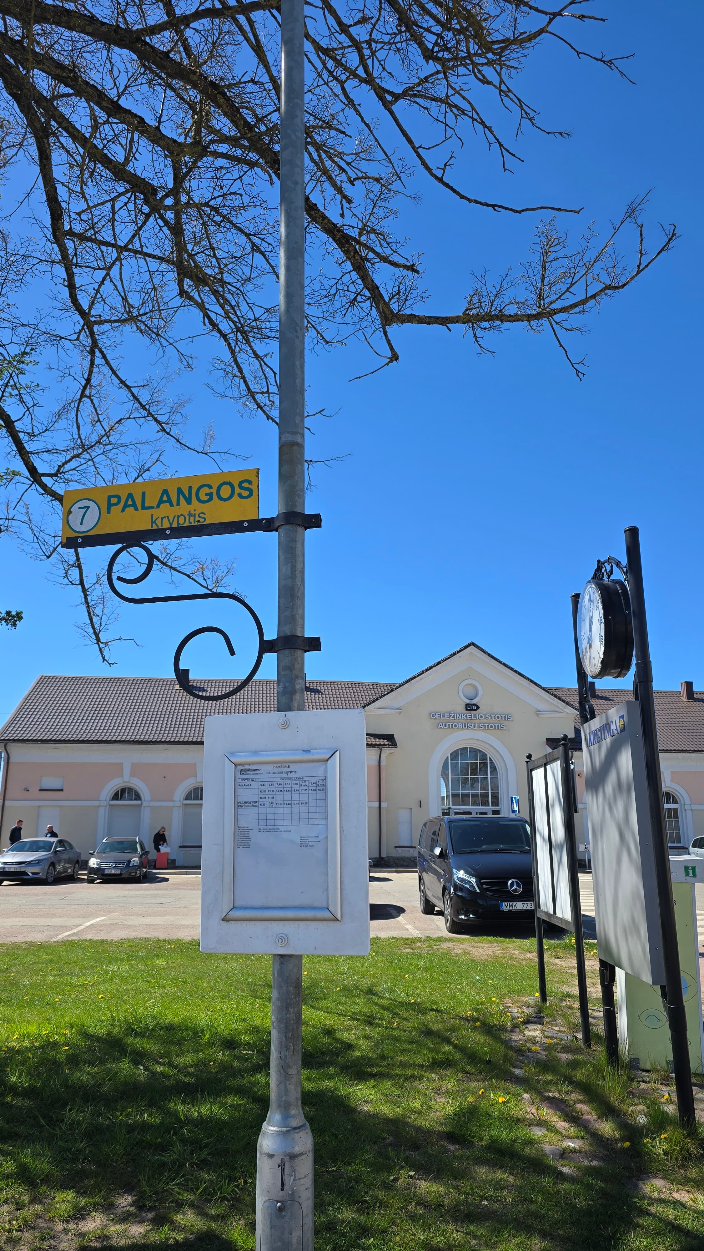 Vertical photo of a bus stop to Palanga with the Kretinga railway station visible in the background