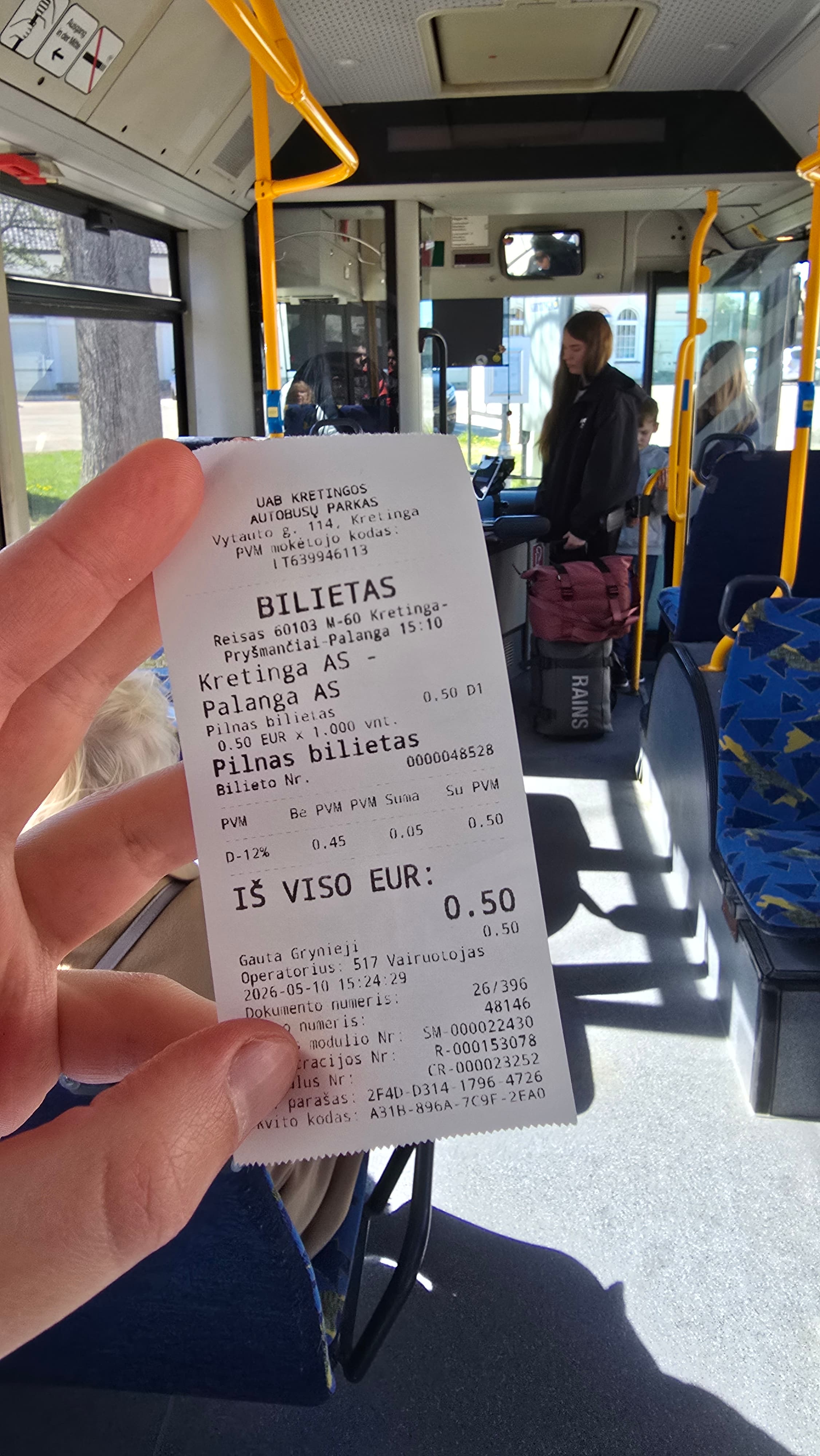 Vertical photo of a bus ticket with background inside the bus